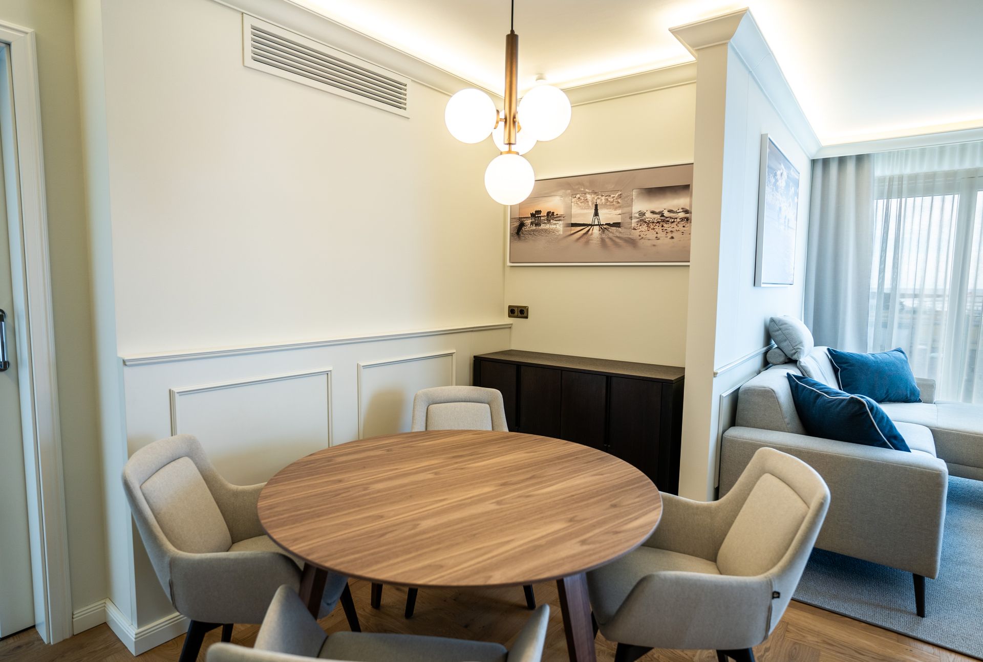 Ein Esszimmer mit einem runden Tisch und Stühlen und einem Sofa.