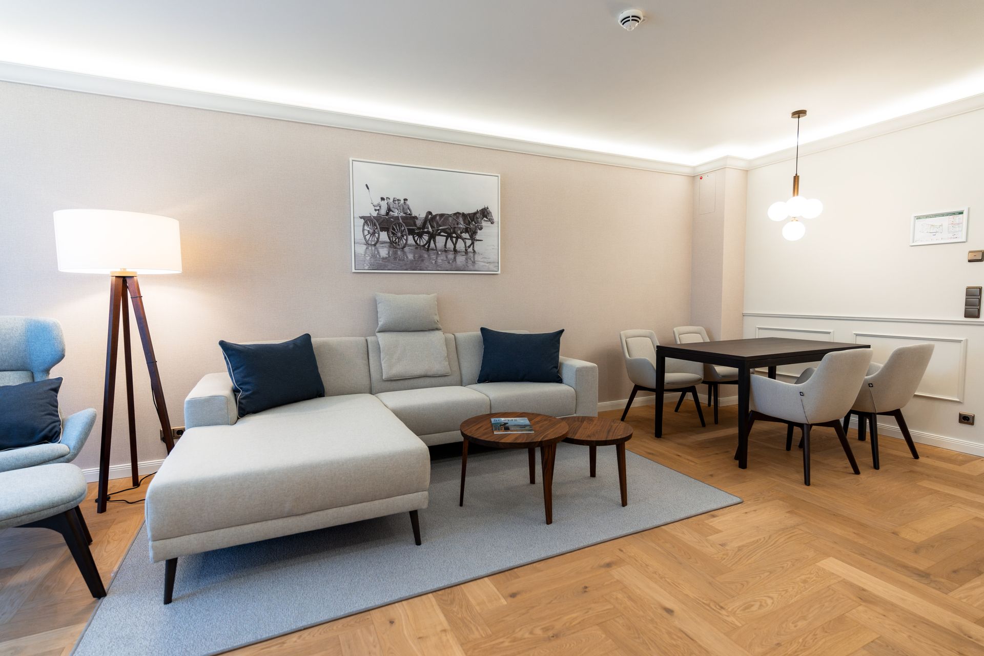 Ein Wohnzimmer mit einem Sofa, Stühlen, einem Tisch und einer Lampe.
