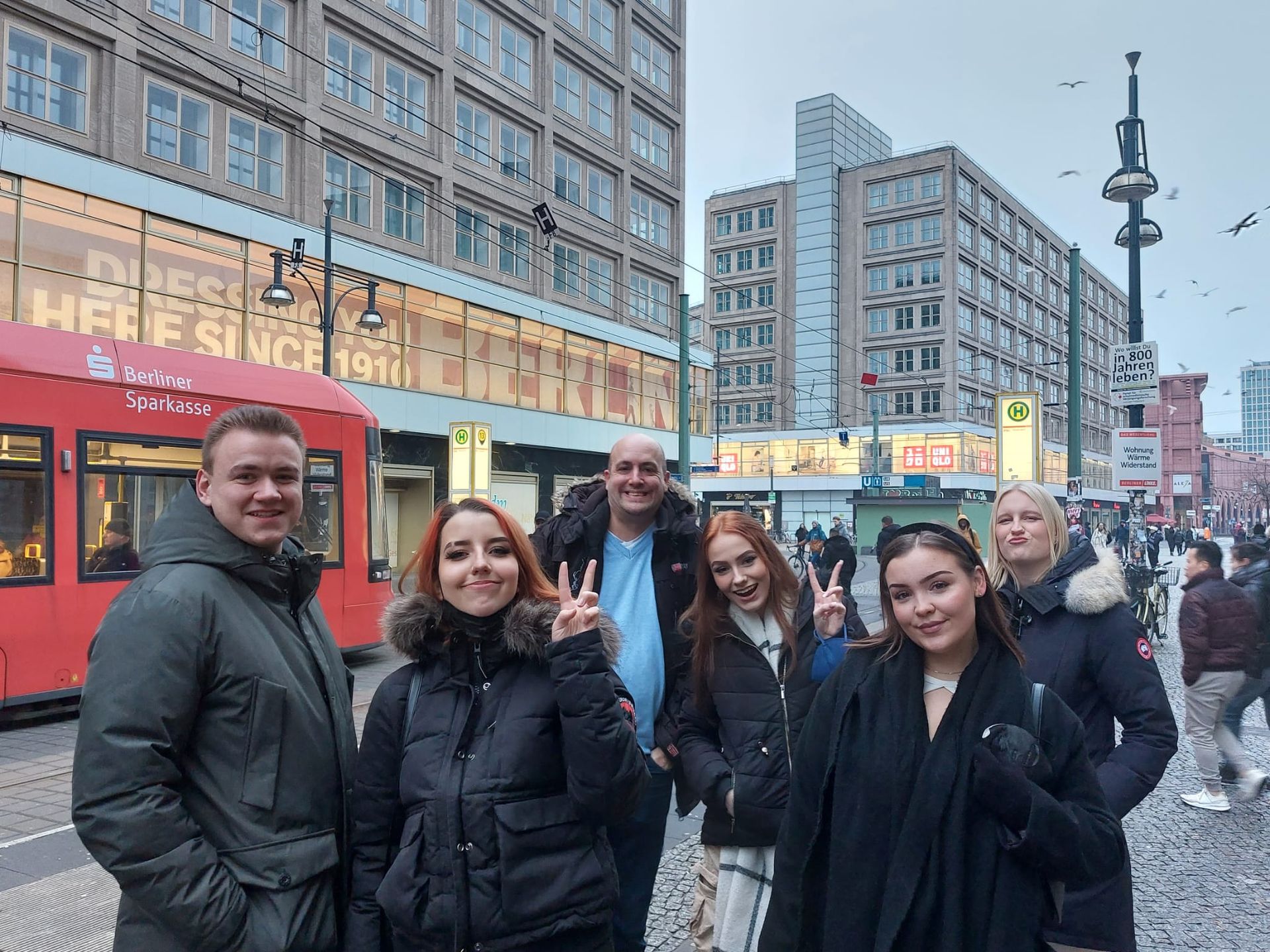 Eine Gruppe von Menschen steht vor einem roten Bus.