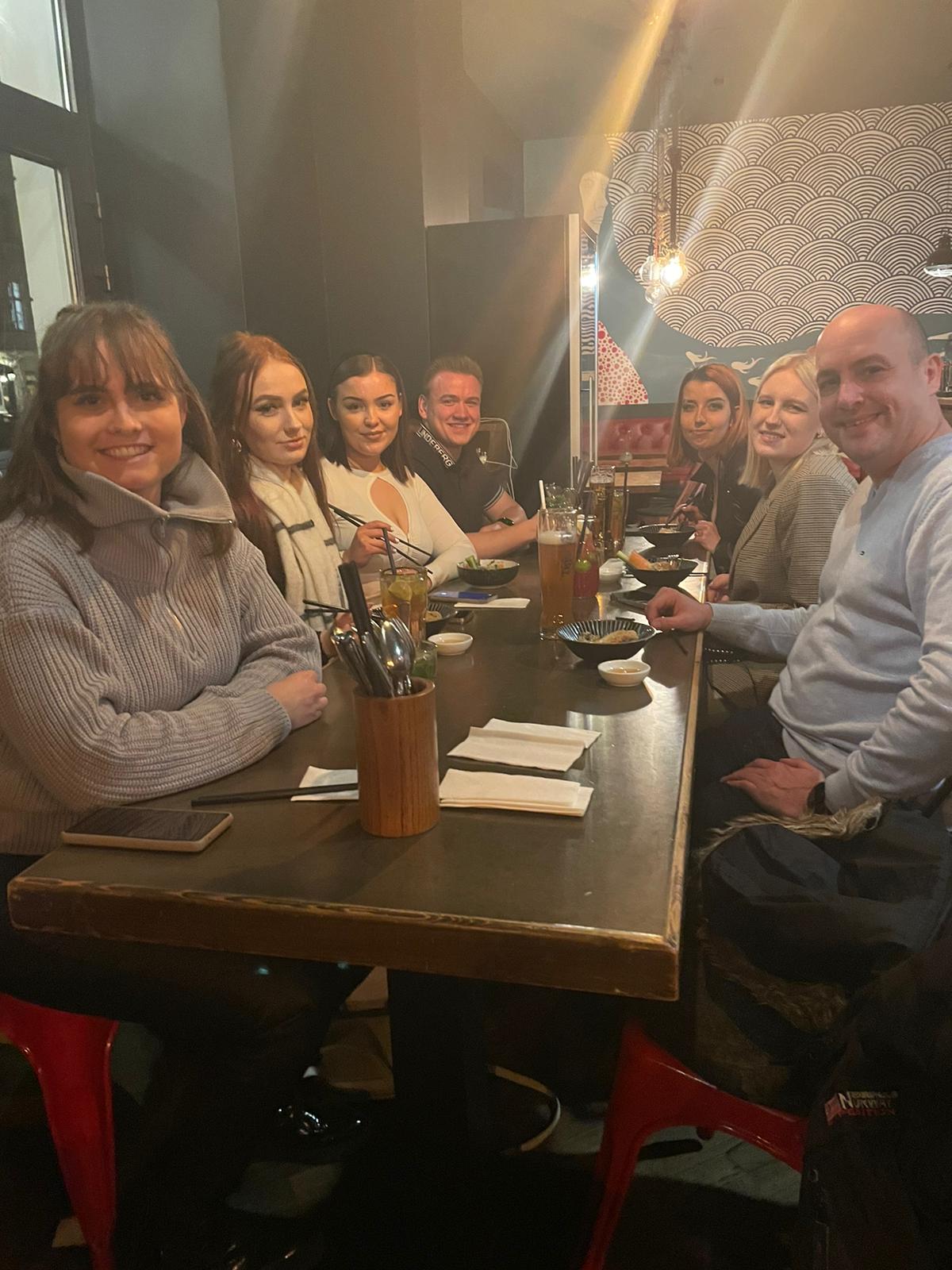 Eine Gruppe von Menschen sitzt in einem Restaurant an einem Tisch.