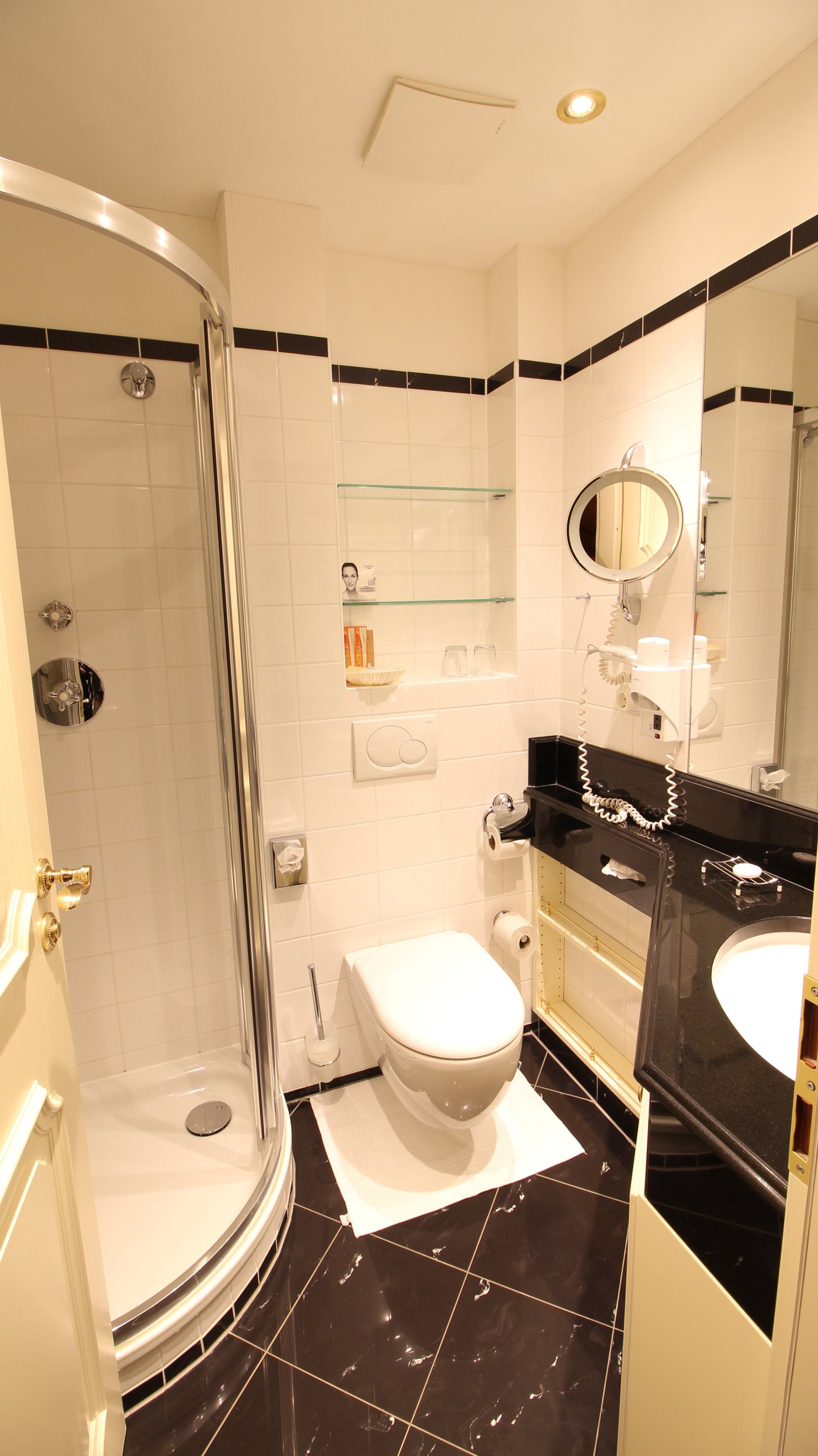 A bathroom with a toilet , sink and shower.