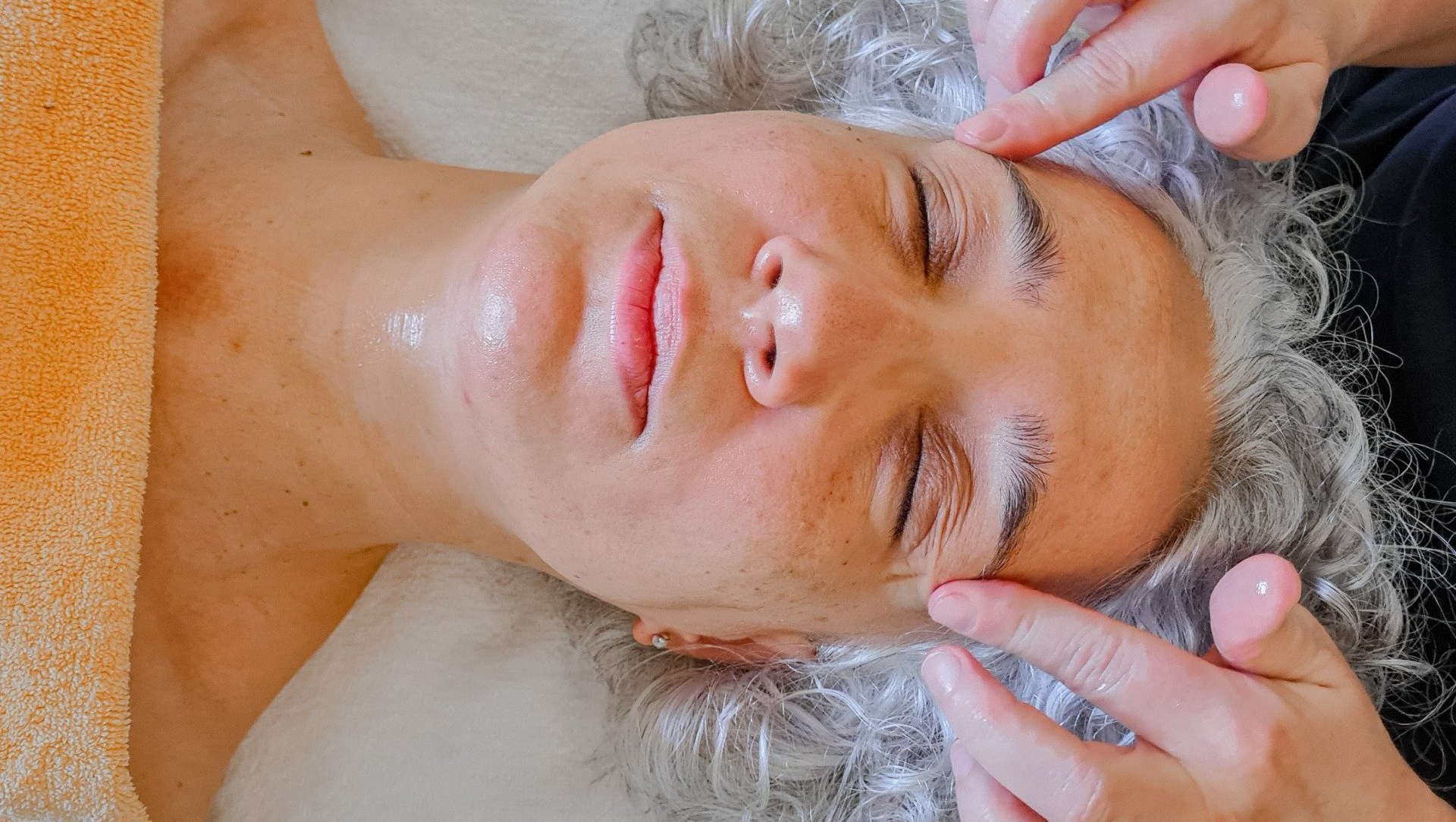 A woman is getting a head massage at a spa.