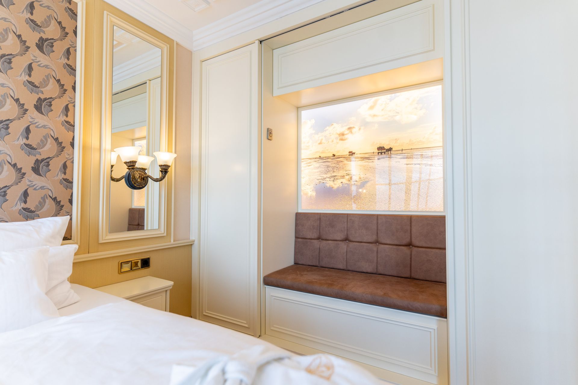 Ein Hotelzimmer mit Bett, Spiegel, Couch und Fenster.