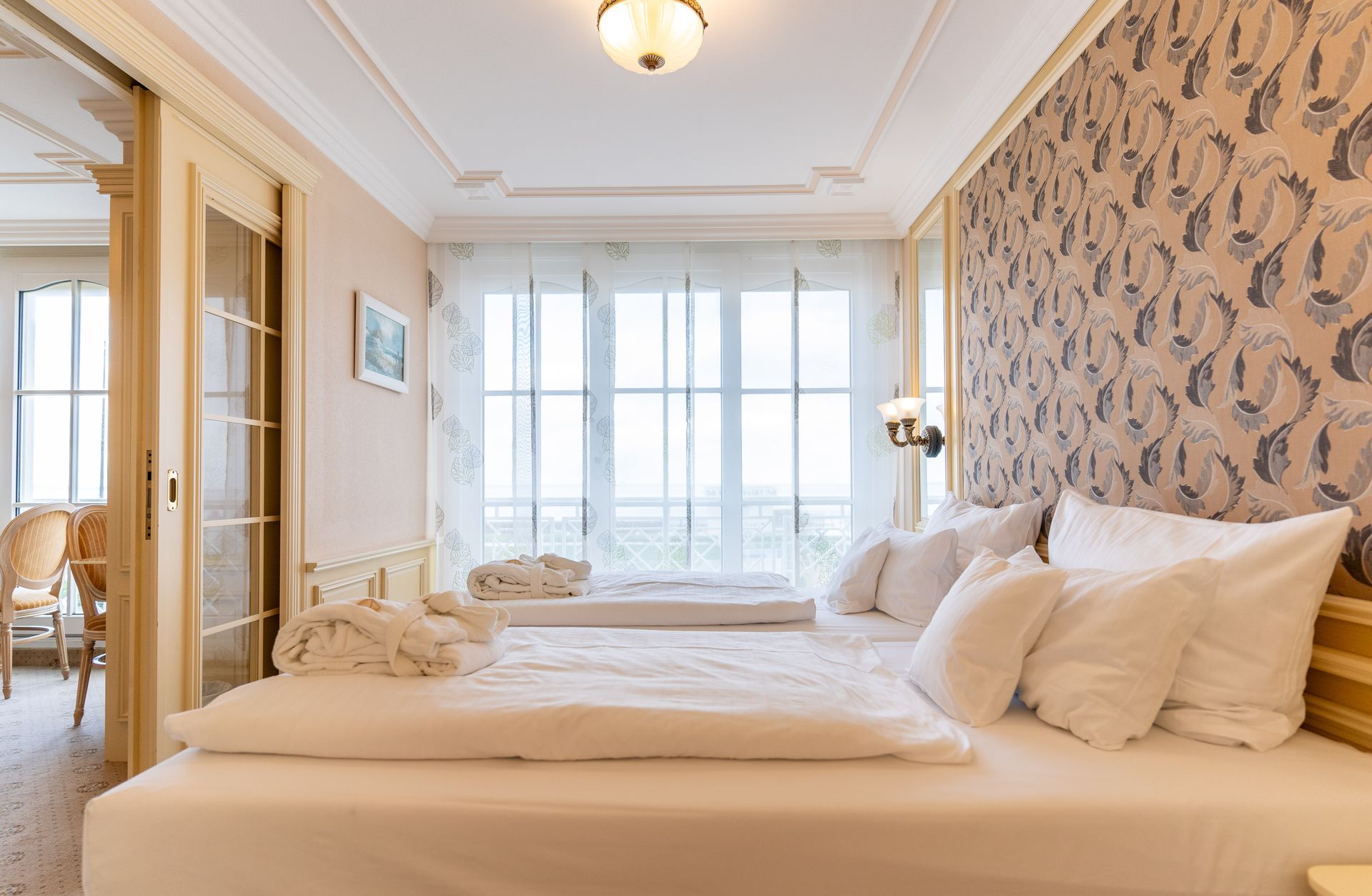 Ein Hotelzimmer mit zwei Betten und einem großen Fenster.
