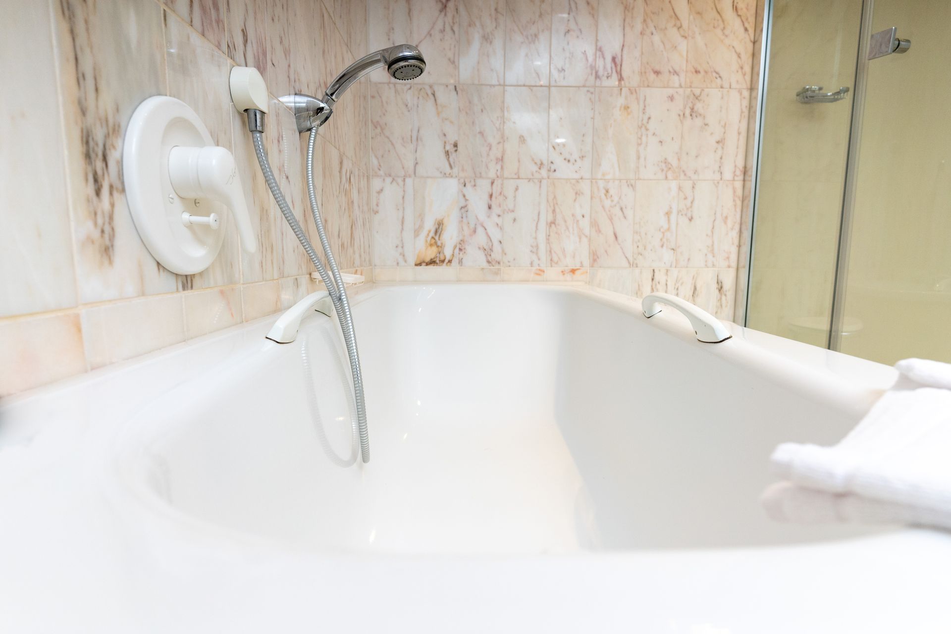 Eine Badewanne mit daran befestigtem Duschkopf in einem Badezimmer.