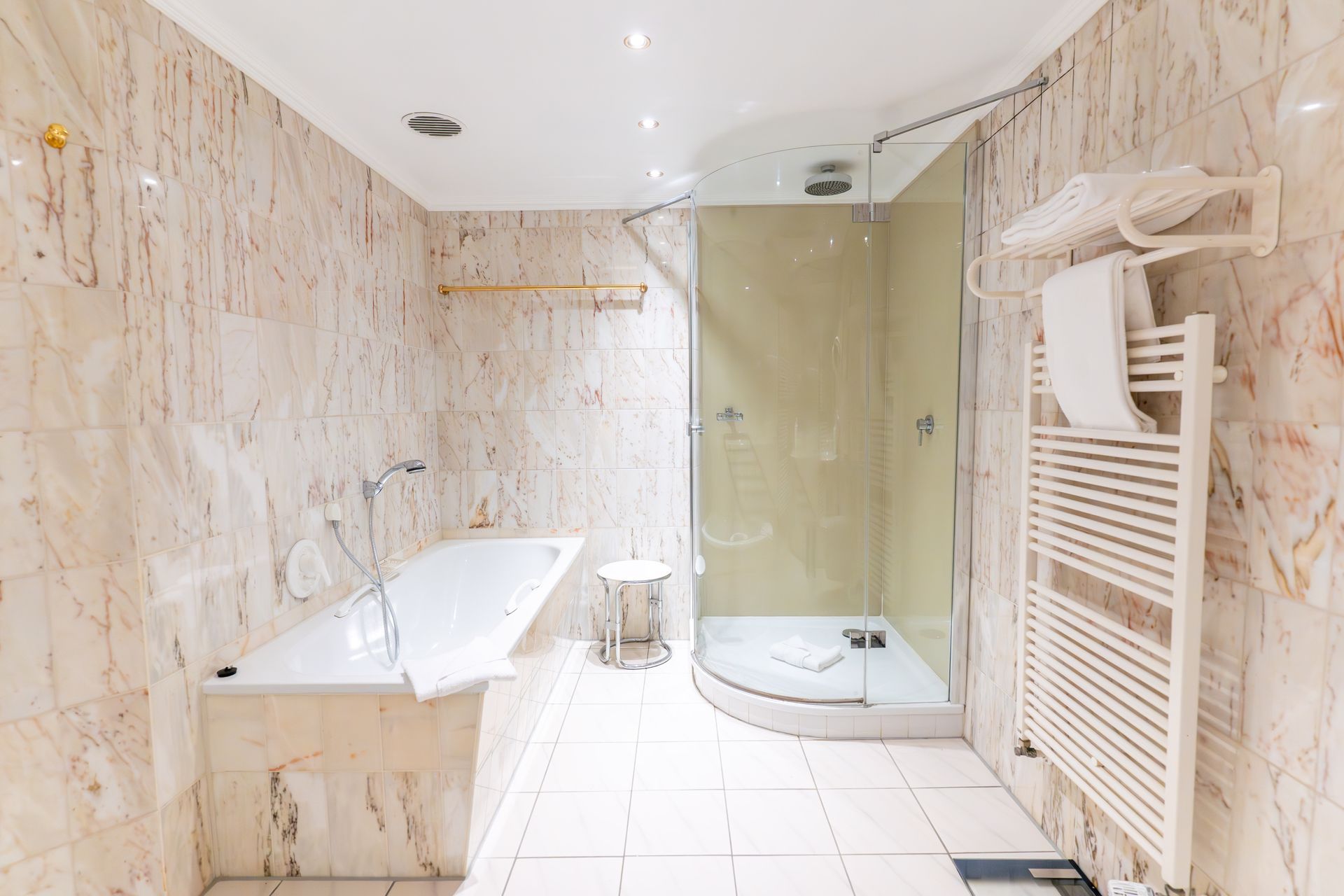 Ein Badezimmer mit Badewanne und ebenerdiger Dusche.
