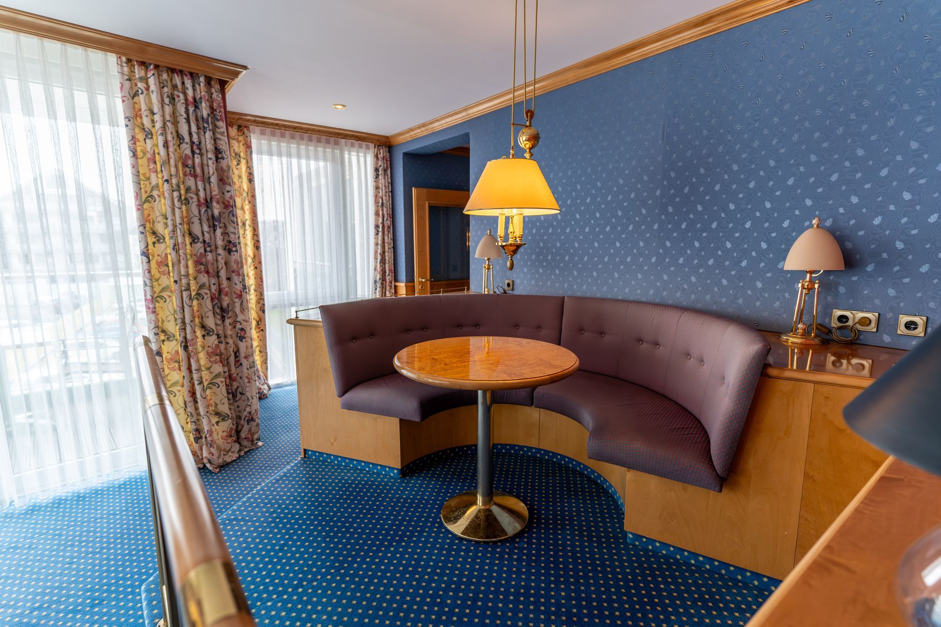 Ein Hotelzimmer mit einem runden Tisch und einer geschwungenen Couch