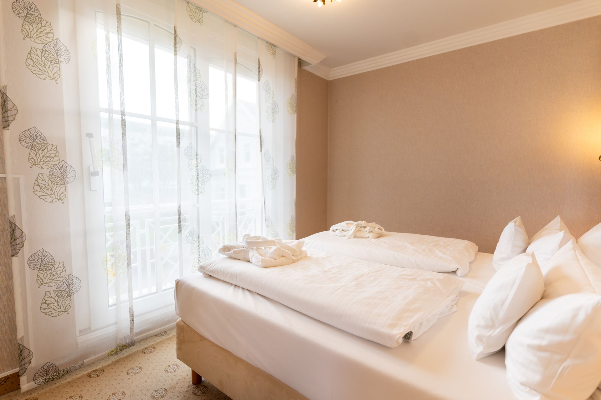 Ein Schlafzimmer mit zwei Betten und einem großen Fenster.