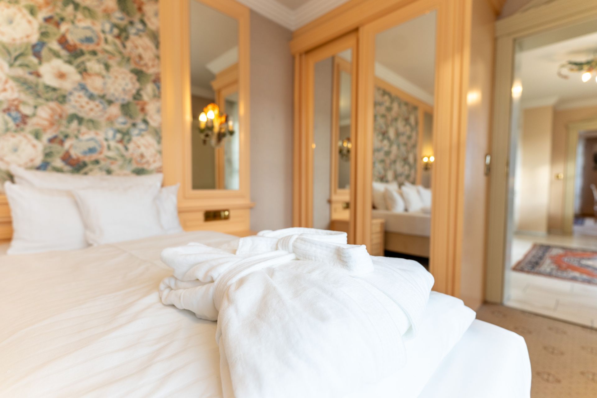 Ein Hotelzimmer mit Bett, Kleiderschrank und Spiegeln.