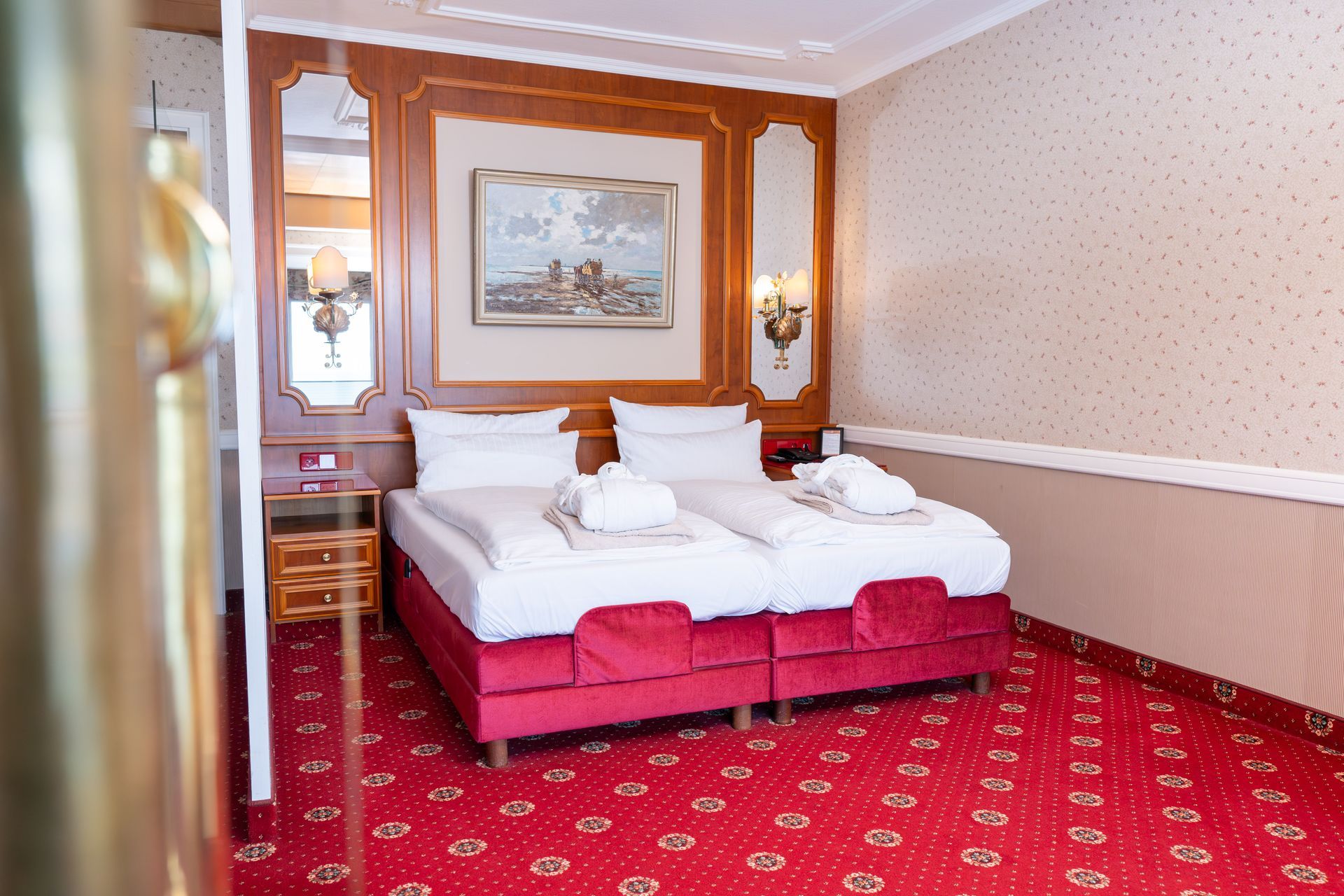 Ein Hotelzimmer mit zwei Betten und einem roten Teppich