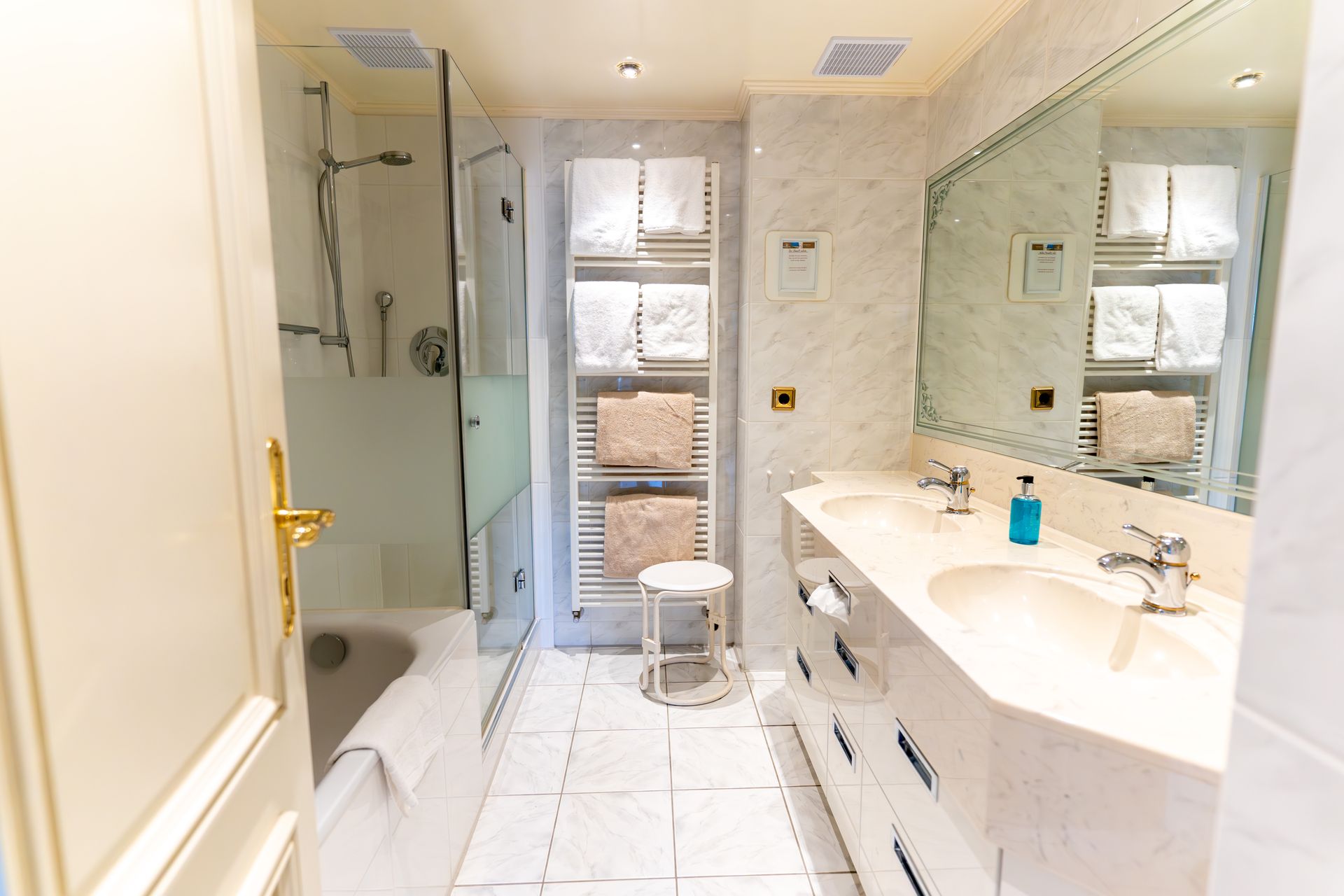 Ein Badezimmer mit zwei Waschbecken, einer Badewanne und einem Spiegel.