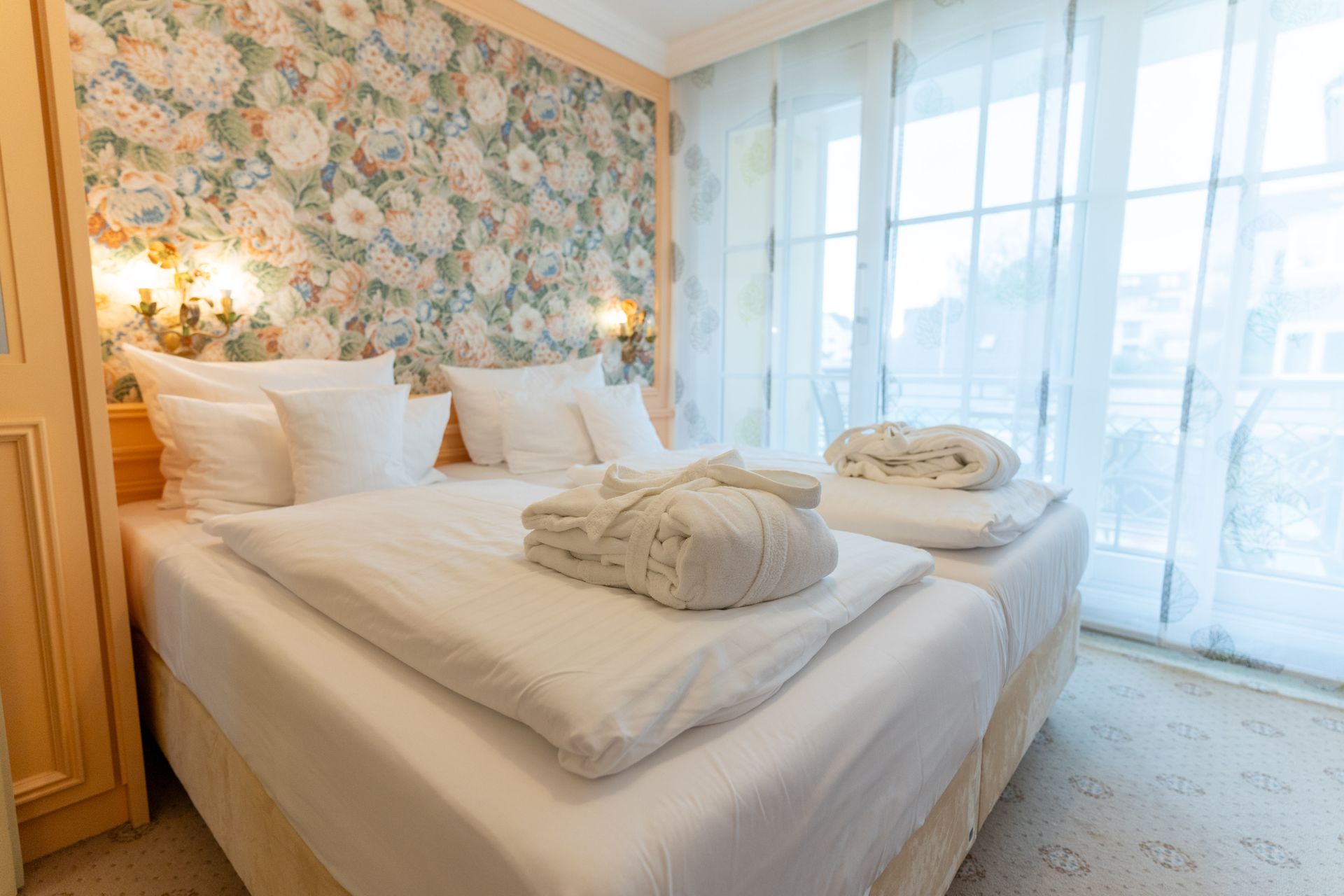 Ein Hotelzimmer mit zwei Betten und einem großen Fenster.