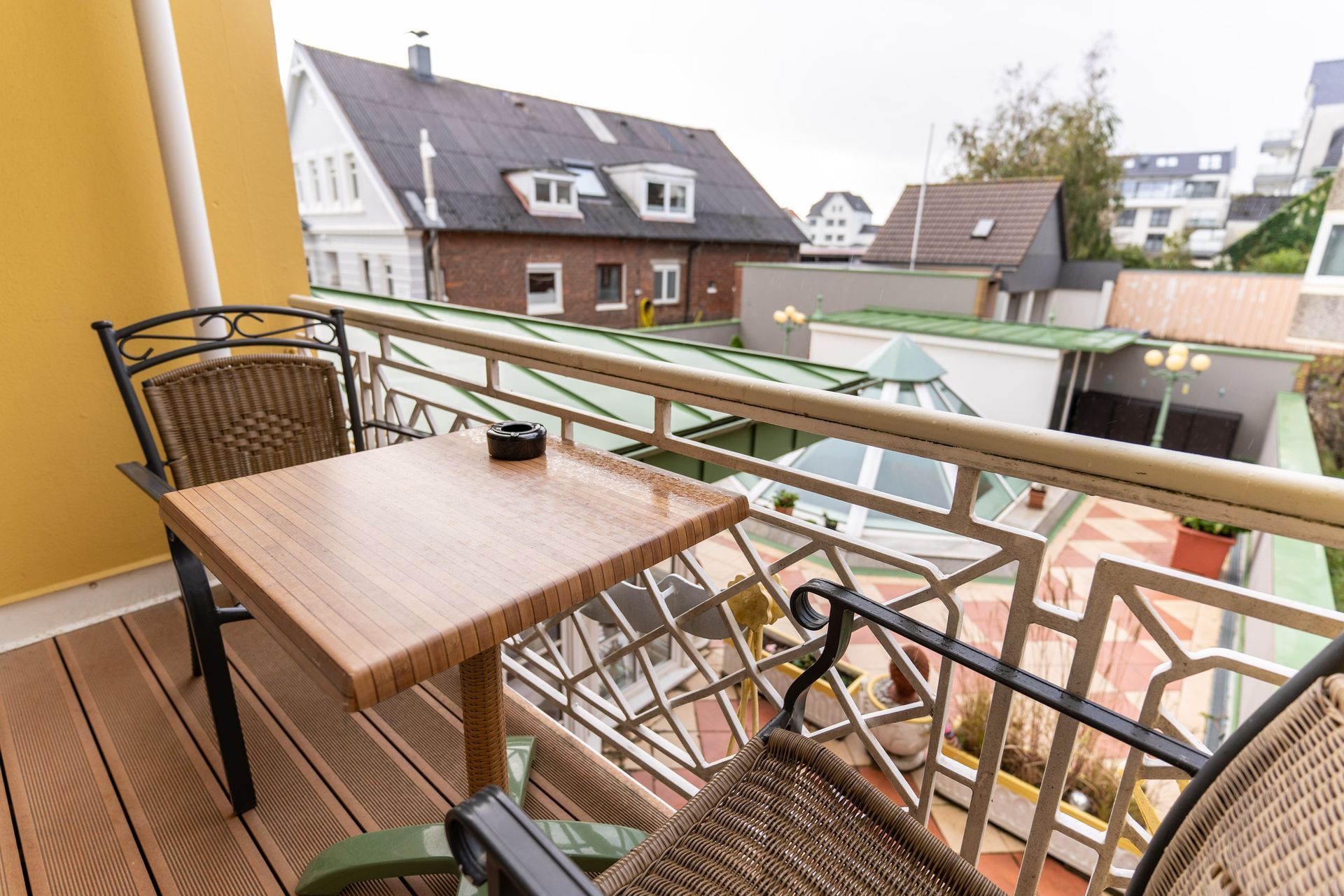 Ein Balkon mit Tisch und Stühlen und Blick auf die Stadt.