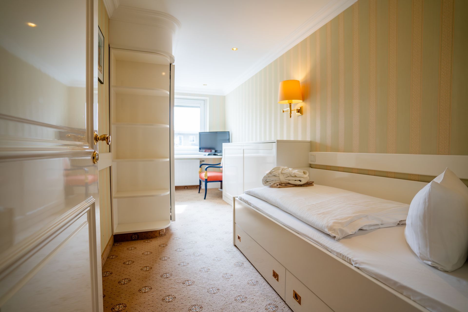 In der Mitte des Zimmers steht ein Einzelbett.