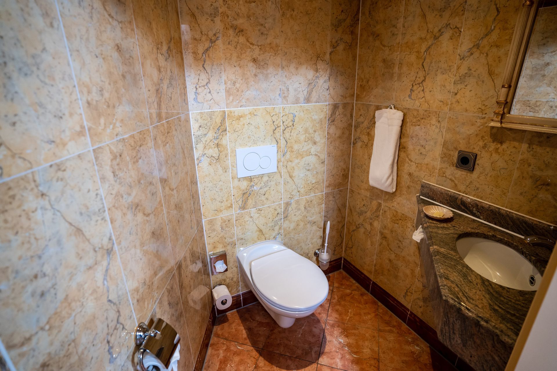 Ein Badezimmer mit Toilette, Waschbecken und Spiegel.
