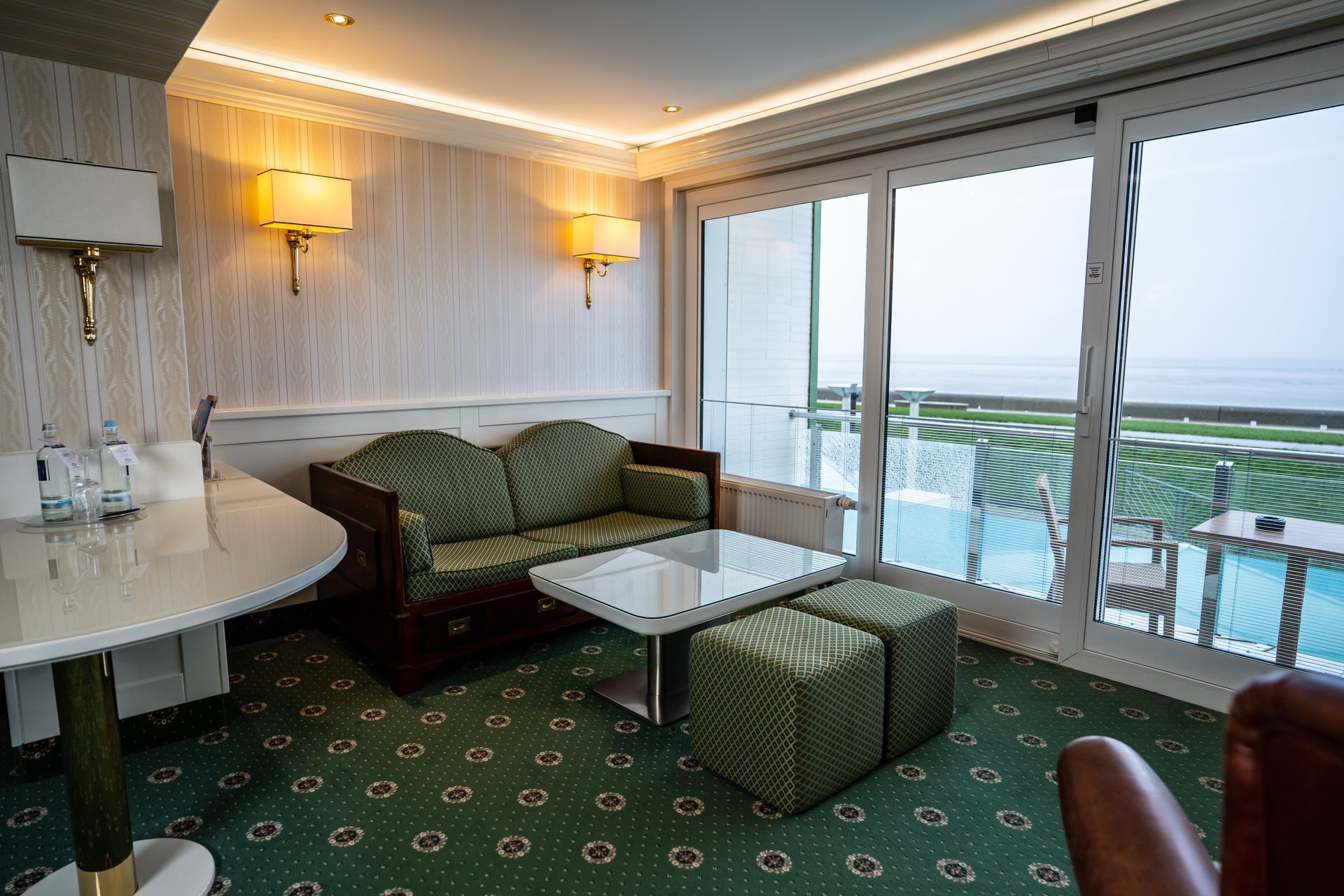 Ein Wohnzimmer mit Couch, Tisch, Stühlen und einem Swimmingpool.