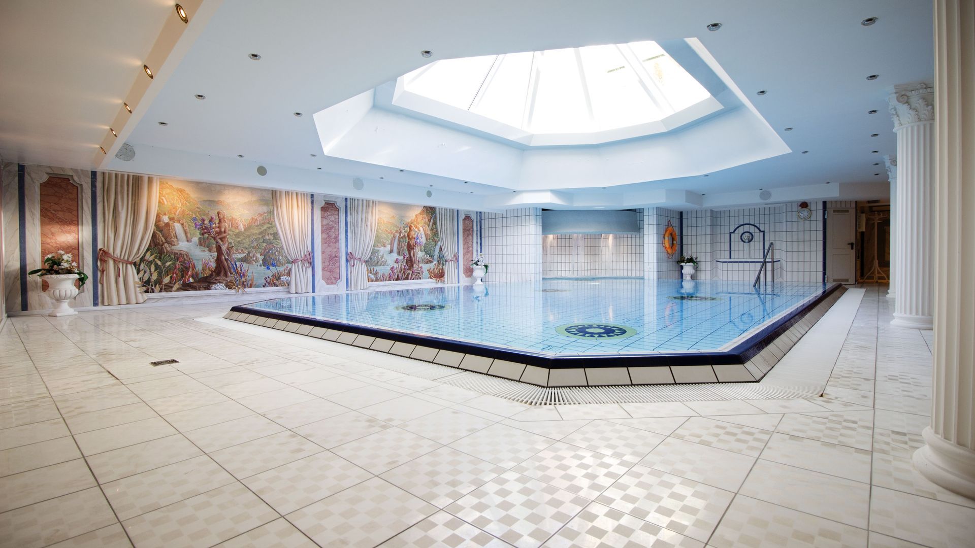 Ein großes Hallenbad mit einem Oberlicht in der Decke.