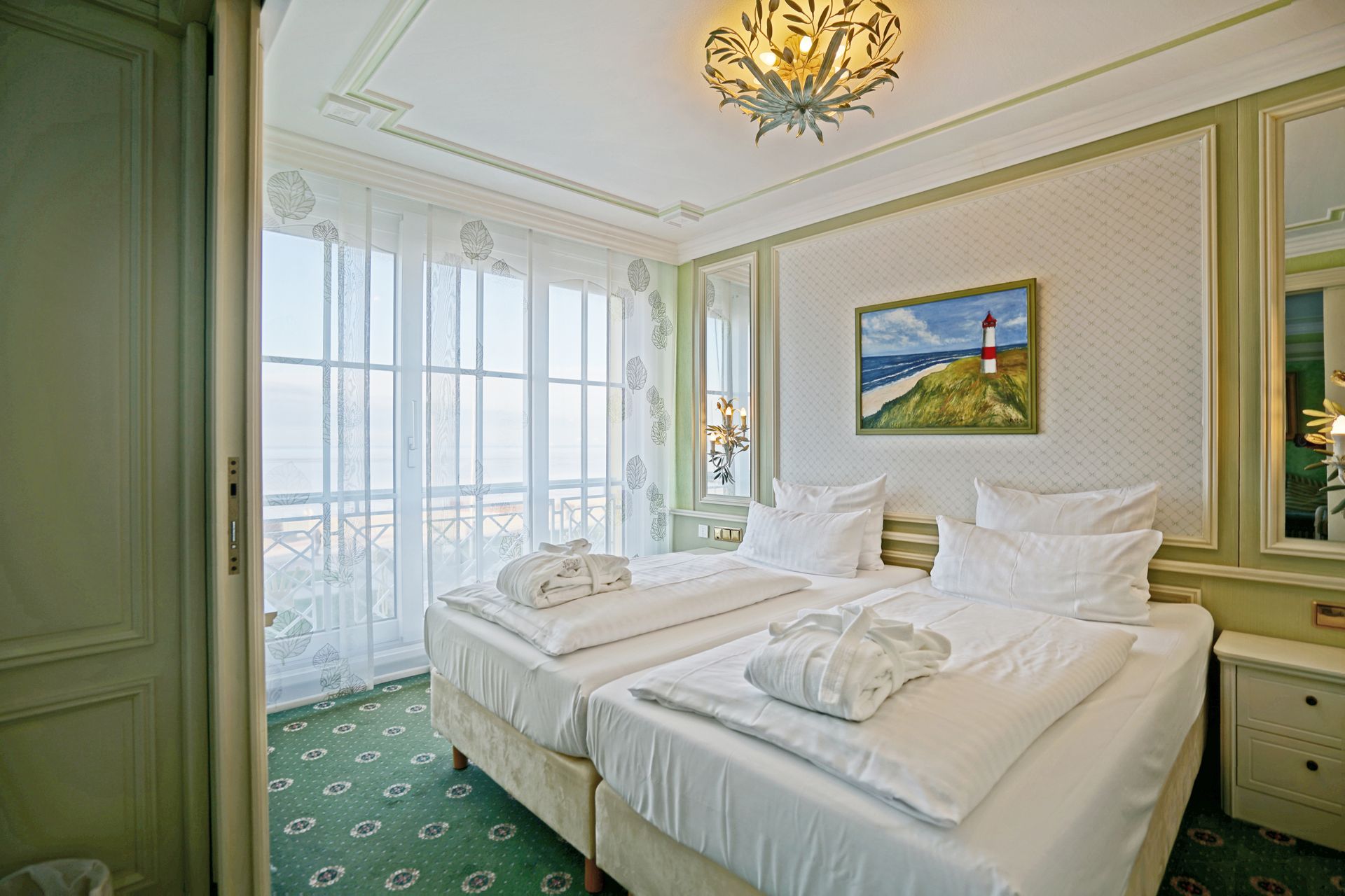 Ein Hotelzimmer mit zwei Betten und einem Leuchtturmgemälde an der Wand.