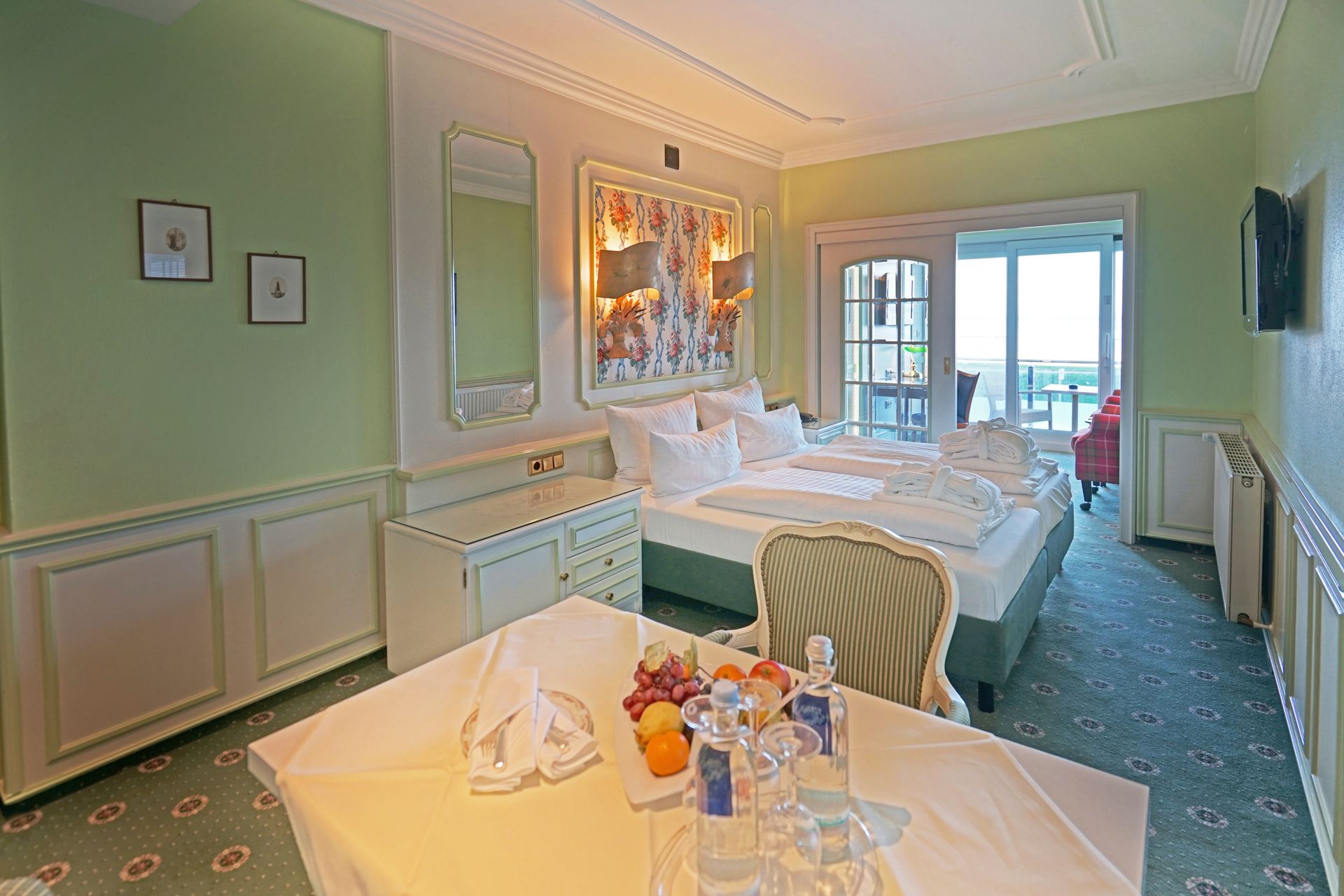 Ein Hotelzimmer mit einem Tisch, Stühlen und einem Bett.