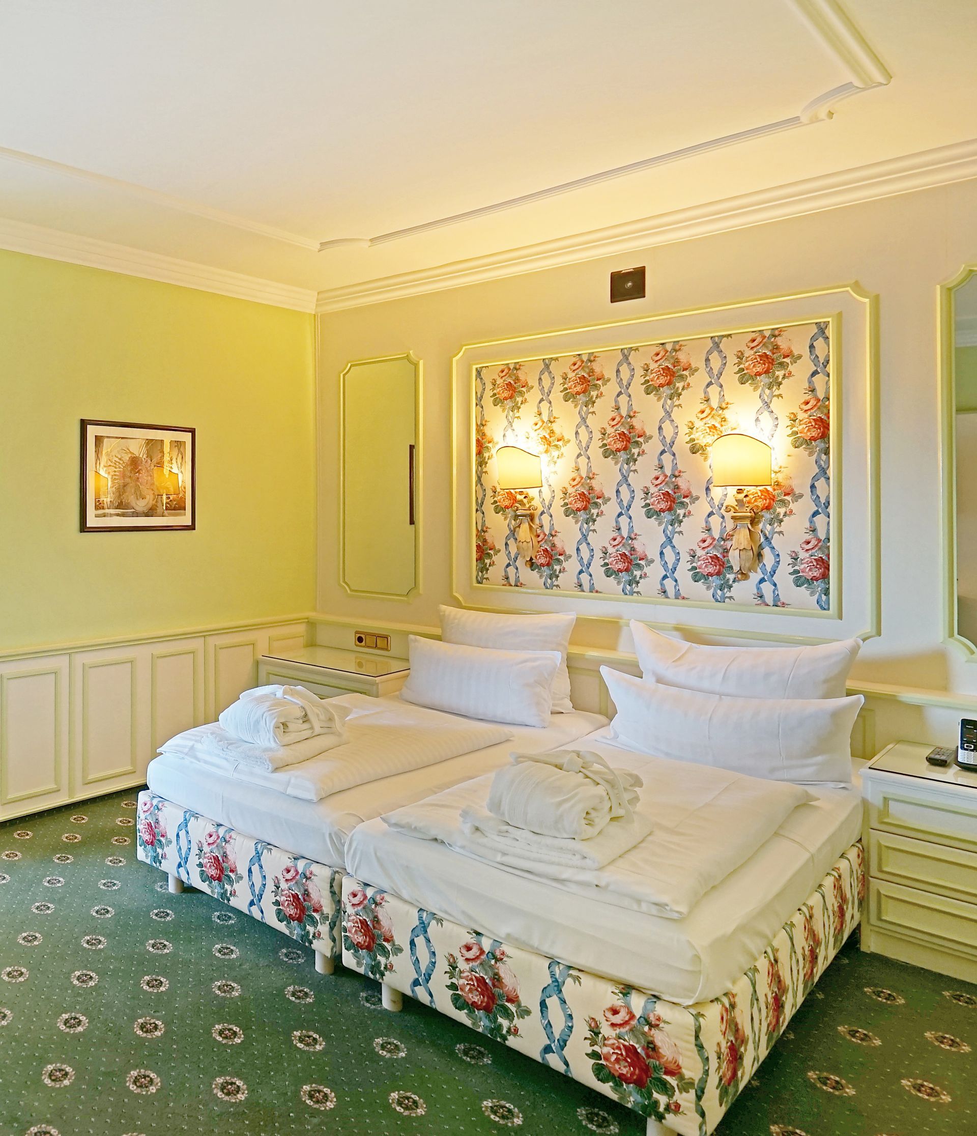 Ein Hotelzimmer mit zwei Betten und einem Bild an der Wand