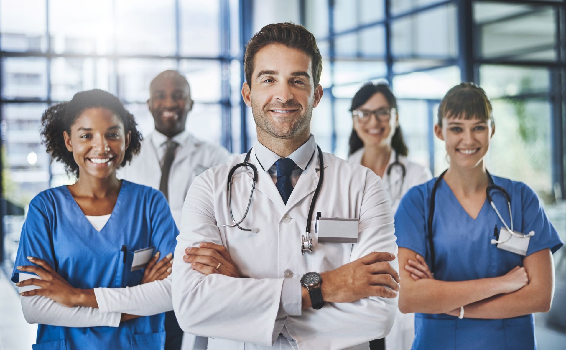 A group of doctors and nurses are posing for a picture in a hospital.