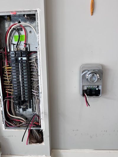 A close up of an electrical box on a wall next to a timer.