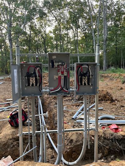 A bunch of electrical boxes are sitting in a hole in the ground.