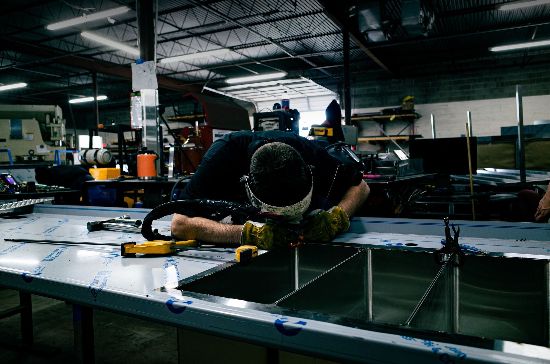 Worker at Integrus Fabrication welding metal fabricated food service equipment