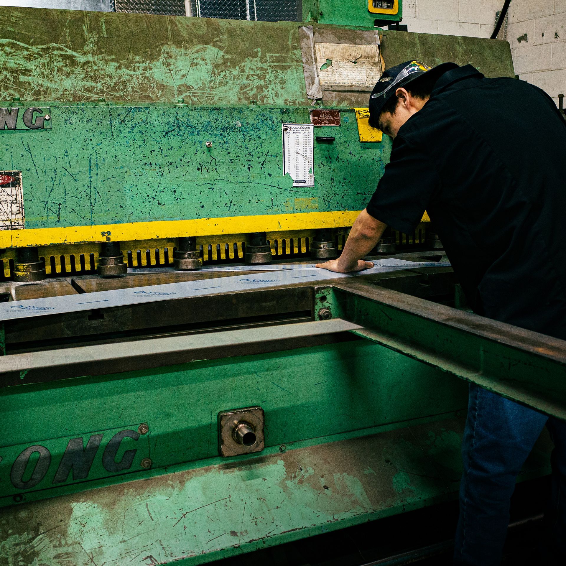 An Integrus Fabrication worker cutting some metal steel / aluminum objects on the Press Brake machine.