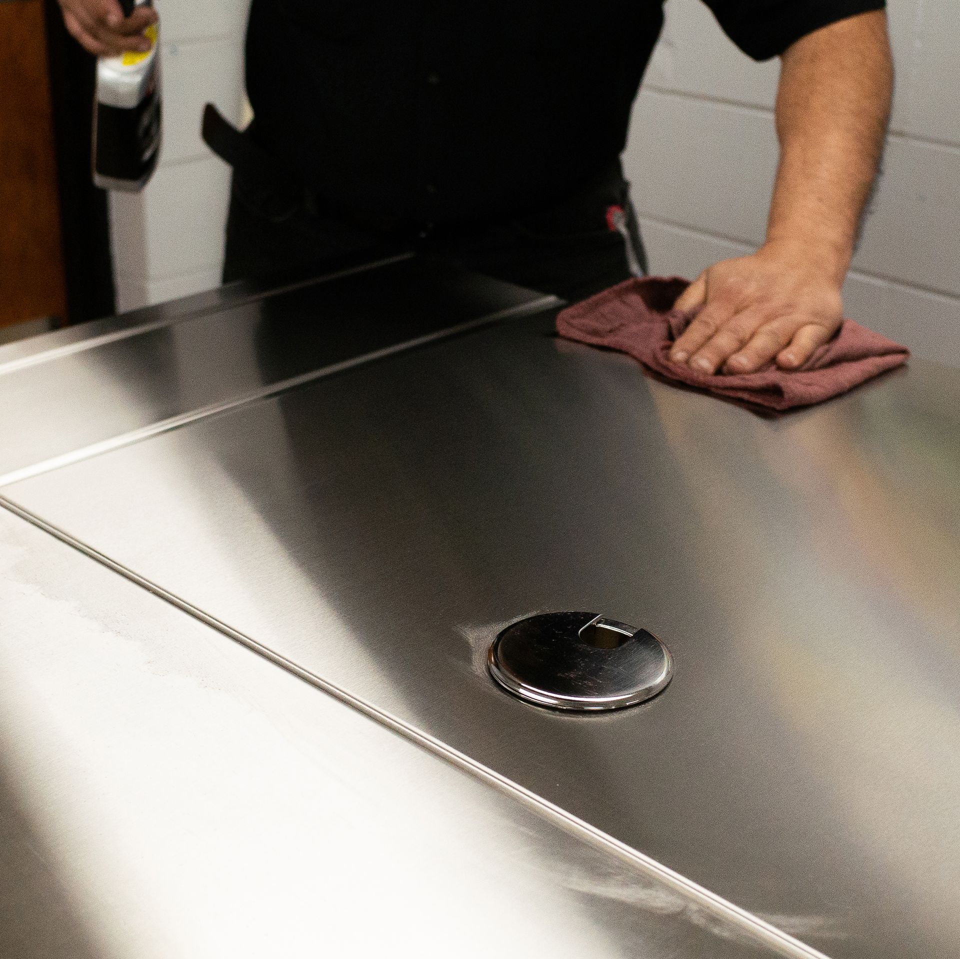A man polishing a plate of metal
