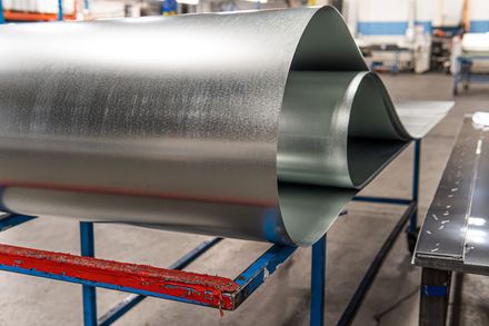 Sheet Metal Fabrication A roll of metal is sitting on top of a table in a factory.