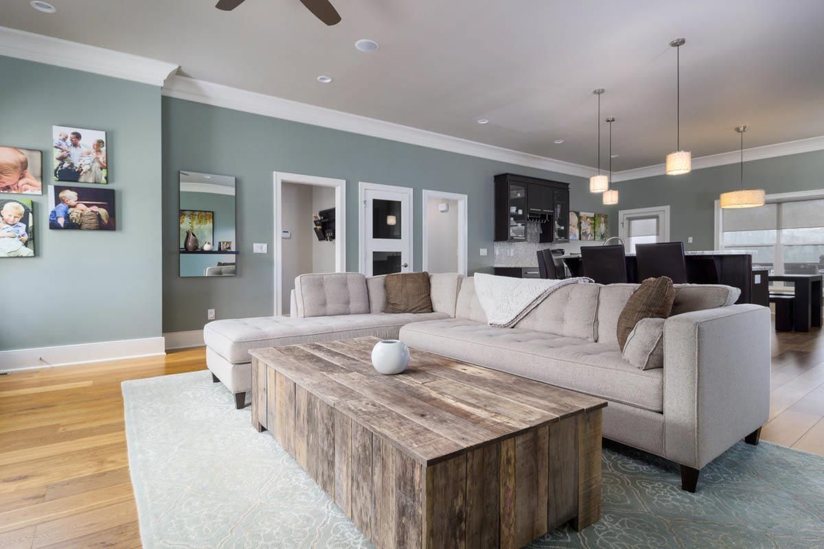 Living room with light-colored couch, wooden coffee table, and light blue walls.