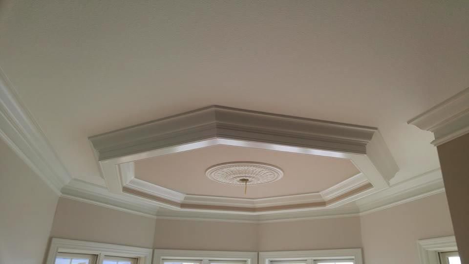 Ceiling with ornate crown molding and a central medallion detail.