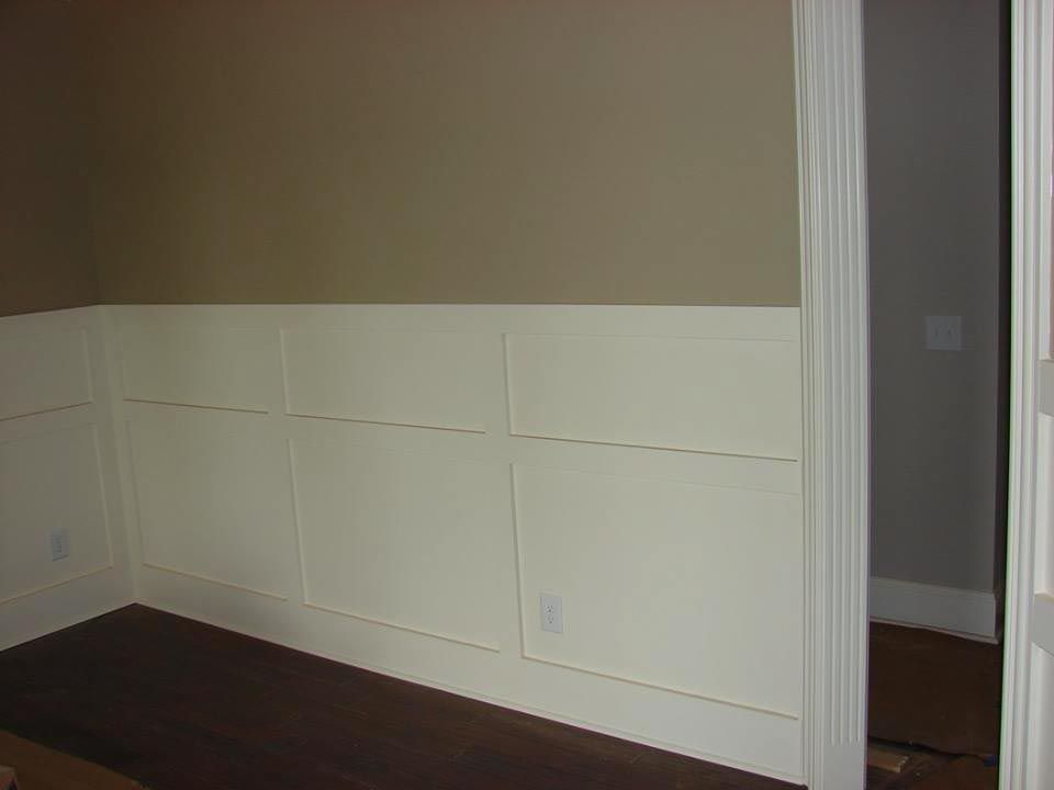Cream wainscoting on brown wall. Dark brown bench. Open door to another room.