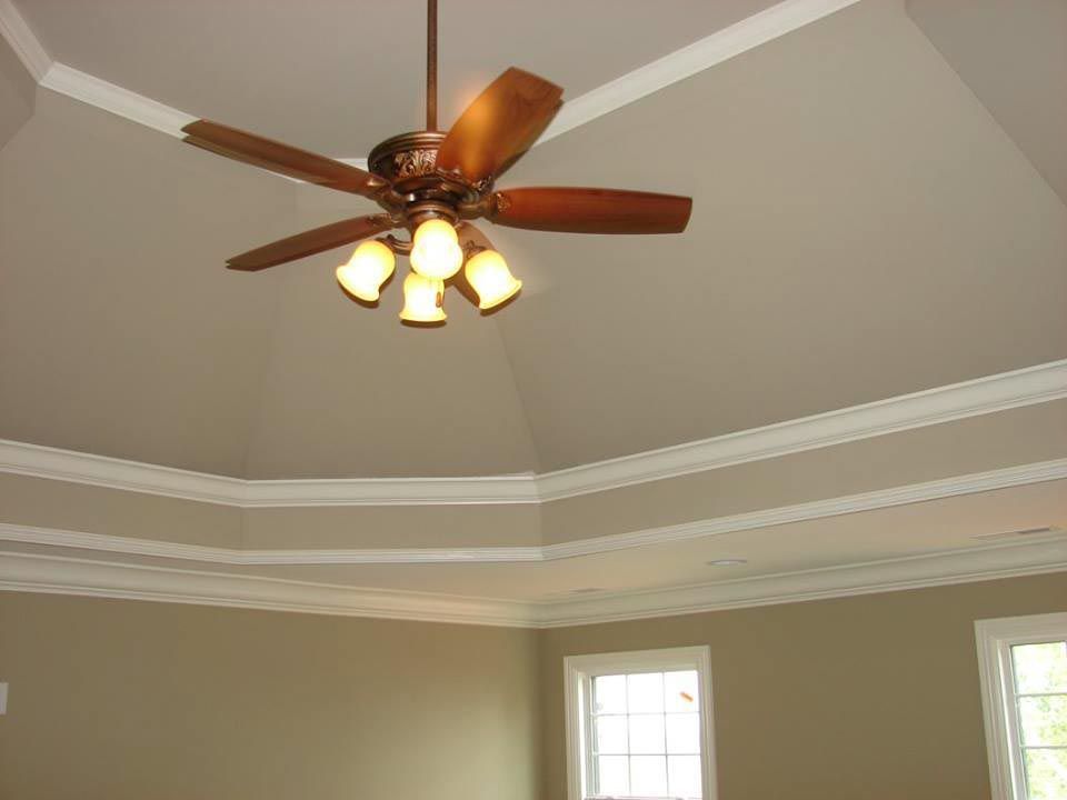 Beige room with coffered ceiling and a ceiling fan.