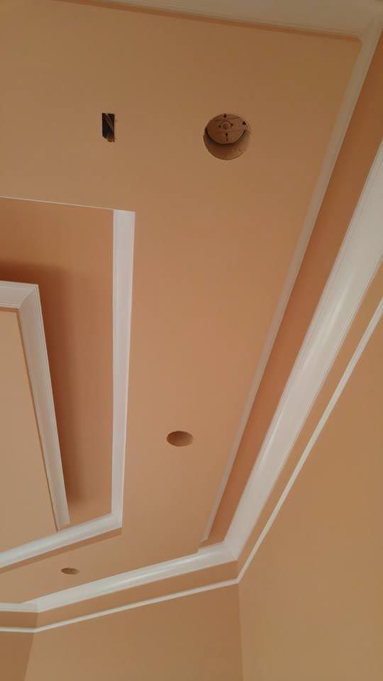 Beige ceiling with white trim, recessed lighting, and a smoke detector.