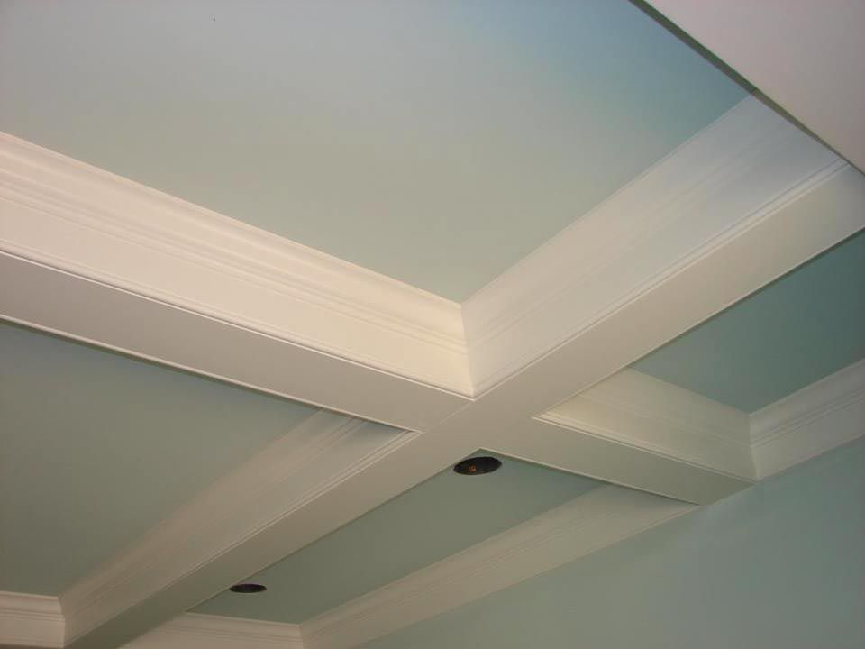 Light blue ceiling with white cross-beams and ornate crown molding. Recessed lighting.