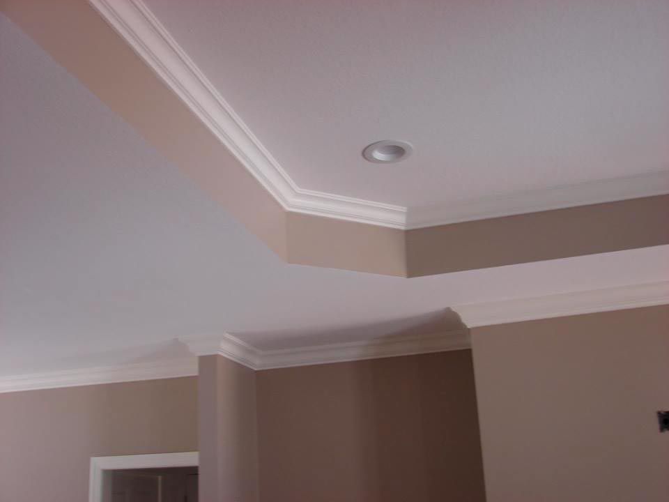White crown molding on a tan wall and white ceiling. A recessed light is visible.