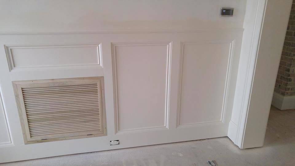 White paneled wall with a vent and door frame.
