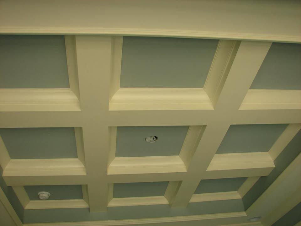 Coffered ceiling with square, recessed panels painted light blue and white trim.