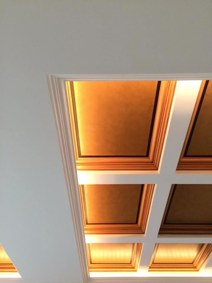 Ornate coffered ceiling with gold-toned recessed squares and white molding.