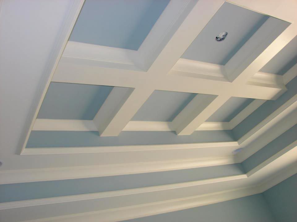 White beams create a coffered ceiling against a light blue backdrop.
