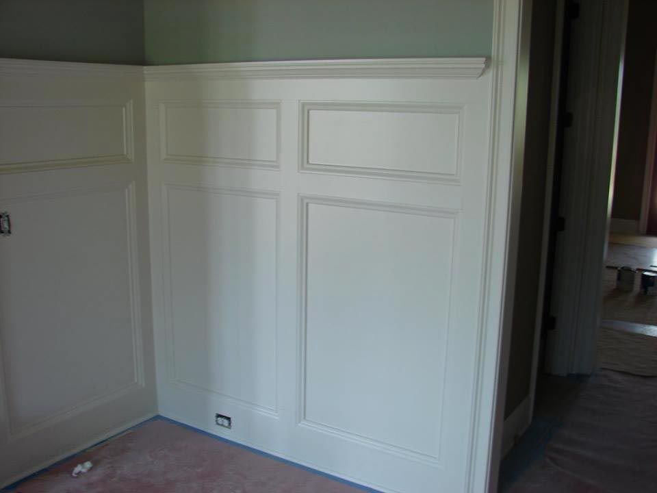 White paneled wall with decorative molding in a room.