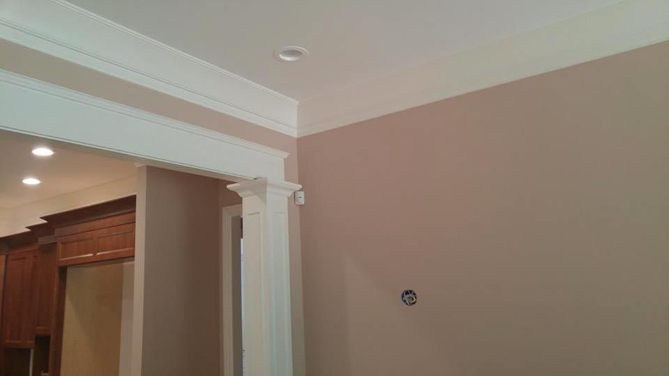 A room corner with light brown walls, white ceiling, and decorative archway.