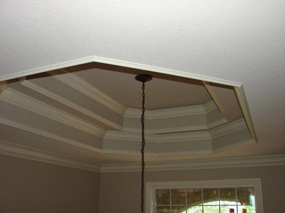 Octagonal ceiling with crown molding and recessed panels; a pendant light hangs from the center.
