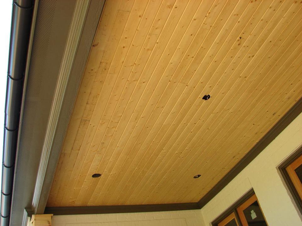 Wood plank ceiling with recessed lighting; brown trim and gutter.
