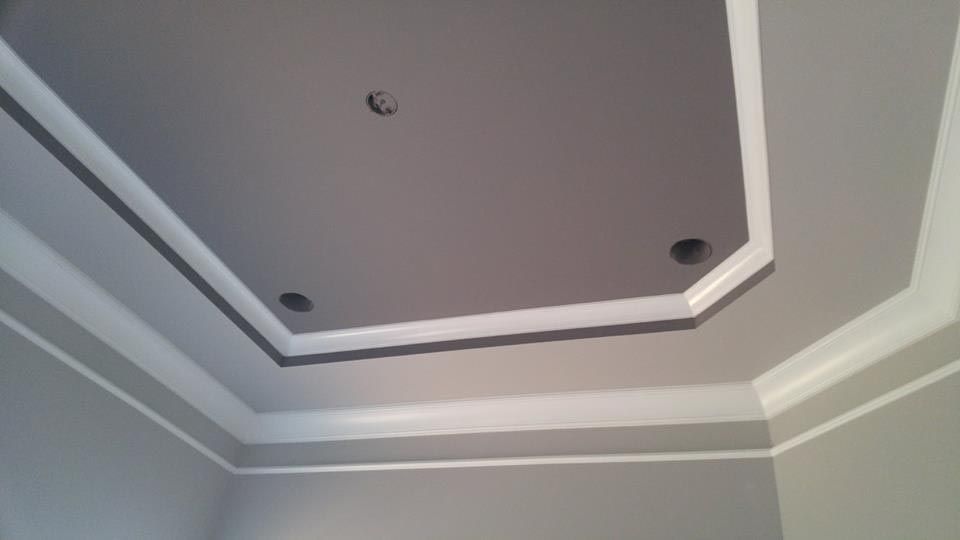 Gray and white ceiling with recessed lighting and crown molding.