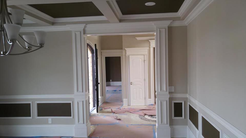 Interior view of a house with white trim, tan walls, and a coffered ceiling.