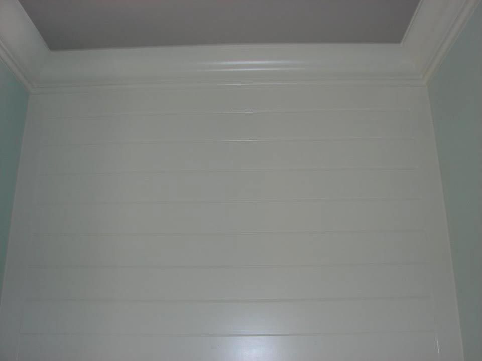 White shower walls with horizontal lines, a light blue side wall, and a recessed ceiling.