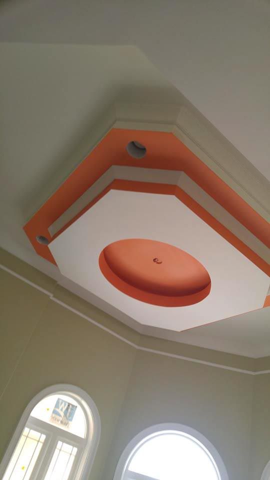 Ceiling with octagonal and circular designs, orange and white paint, recessed lights.